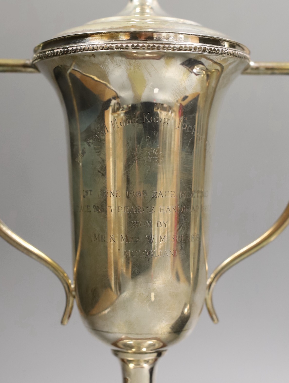 A pair of Royal Hong Kong Jockey Club sterling presentation two handled trophy cups and covers, fixed to wooden plinth bases, height of cups 26cm.